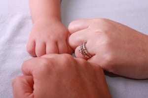 Couple with new baby's hands in a circle